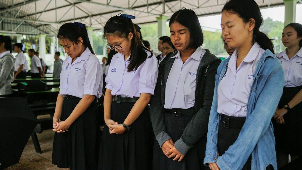 Classmates of the Wild Boars soccer team pray at the Maisai Prasitsart school before classes the morning as the third rescue mission to free the last four boys and their coach from a flooded cave is under way