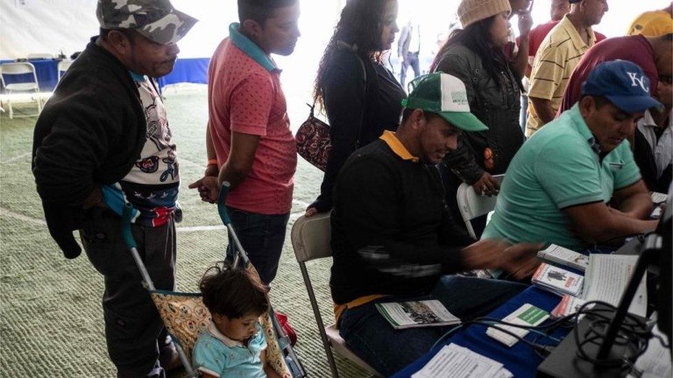 Migrants queue to register at an employment fair near the US-Mexico border in Tijuana, Mexico, on November 19, 2018