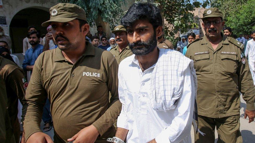 Policemen escort hand-cuffed Muhammad Waseem (C), the brother of slain social media celebrity Qandeel Baloch, as he leaves the court after the verdict in Multan on September 27, 2019