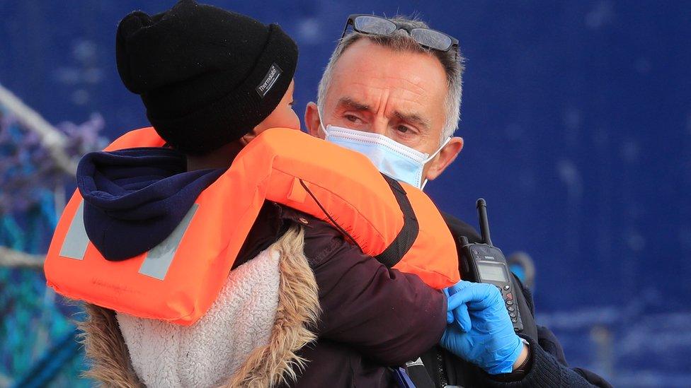 Young child migrant being brought ashore at Dover