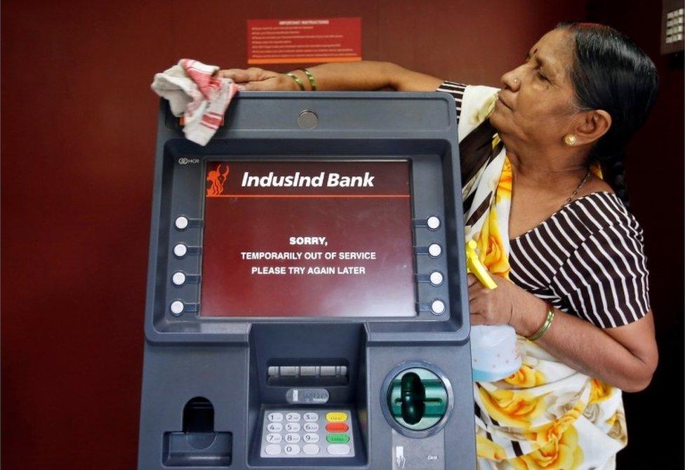 A woman cleans an ATM which is out of service in Mumbai, India, November 11, 2016