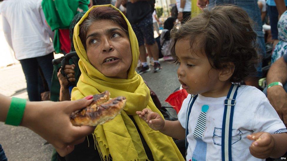 Ahmed (R) and his family from Kabul, Afghanistan, who arrived by train from Hungary via Austria, wait for transportation to one of the migrant reception centres, at Munich's central train station, in Munich, Germany, 01 September 2015.