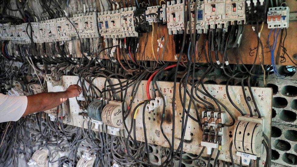 A technician controls an electric switchboard connecting homes to electricity generators in a suburb of Lebanon's capital Beirut, on June 23, 2021.