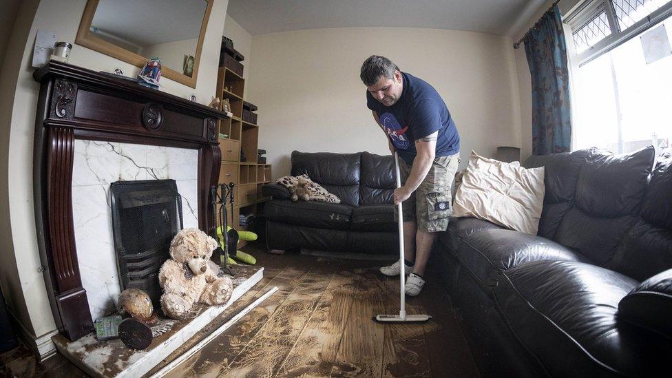 A resident cleaning his house following the flooding in Newcastle