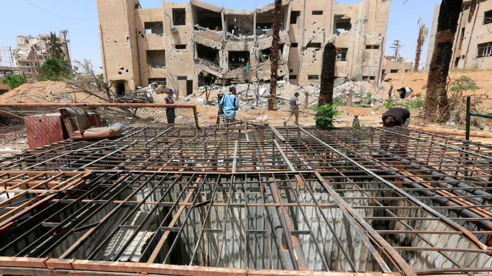 Journalists take pictures of abandoned prison cells formerly used by rebel fighters in the former rebel-held Syrian town of Douma on the outskirts of Damascus (19 April 2018)