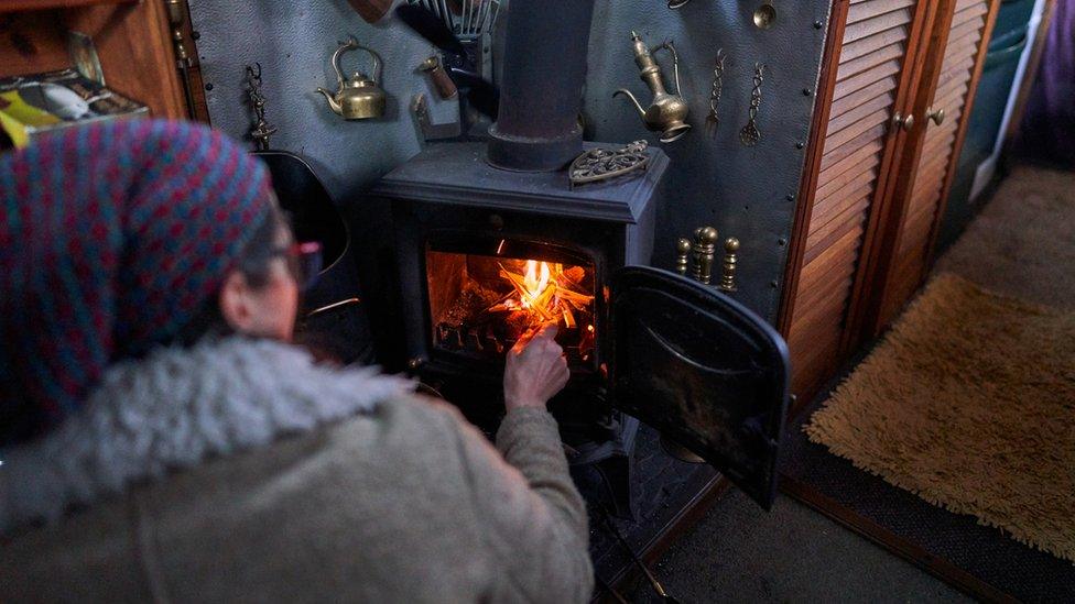 Man lighting a woodburner on a canal boat