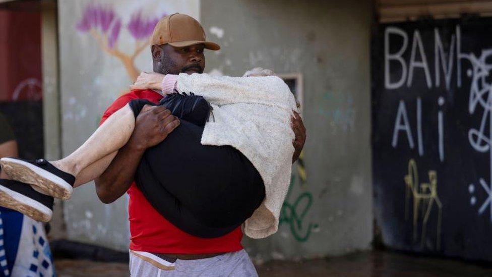 Residents of the Farrapos neighborhood receive help to evacuate their homes following the flooding in Porto Alegre.