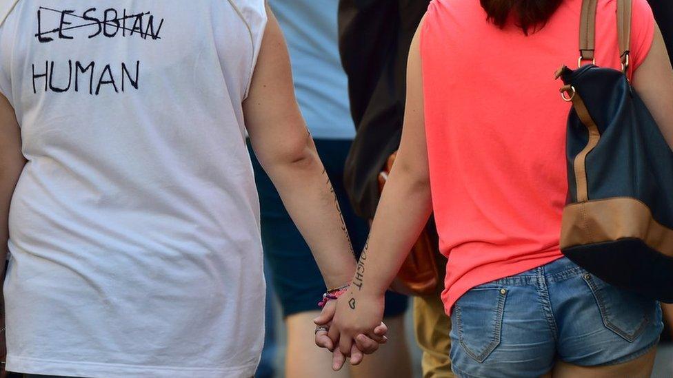 People hold hands as they take part in the annual Lesbian, Gay, Bisexual and Transgender (LGBT) Pride Parade in Milan, on 27 June 2015