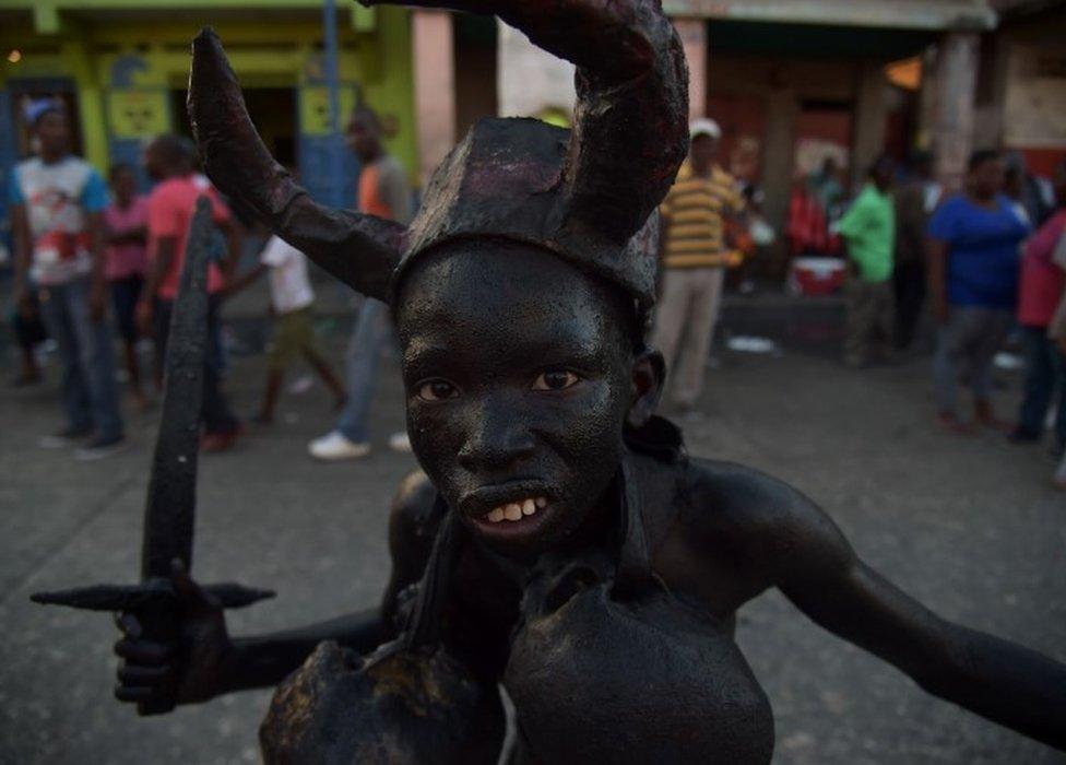 A youth painted with a mixture of cane sugar syrup and coal and wearing skulls in Port-au-Prince, Haiti. Photo: 28 February 2017