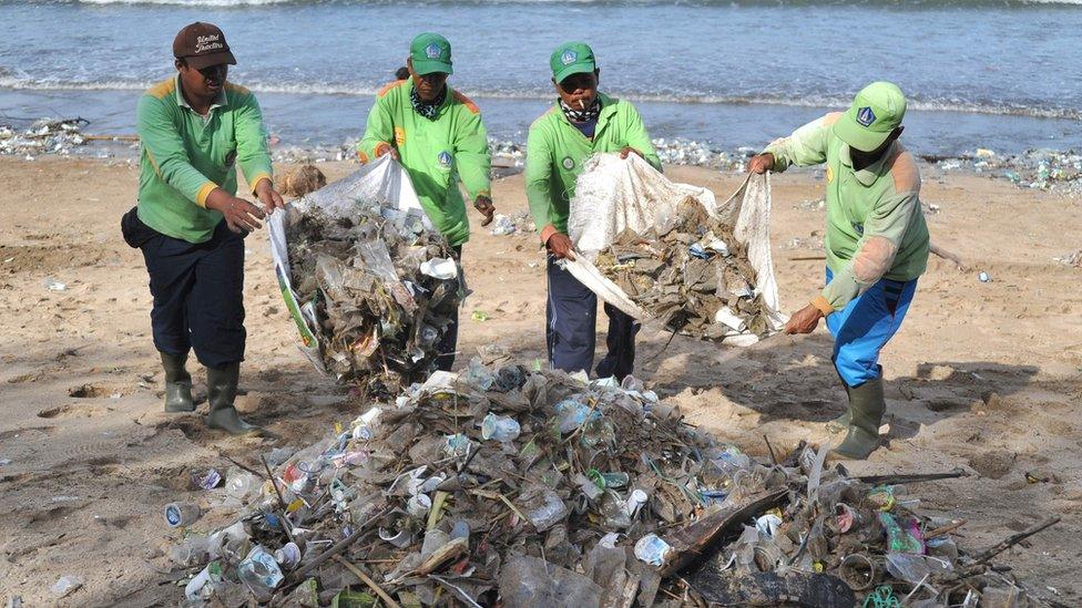 People work to clean up the mess on the beach