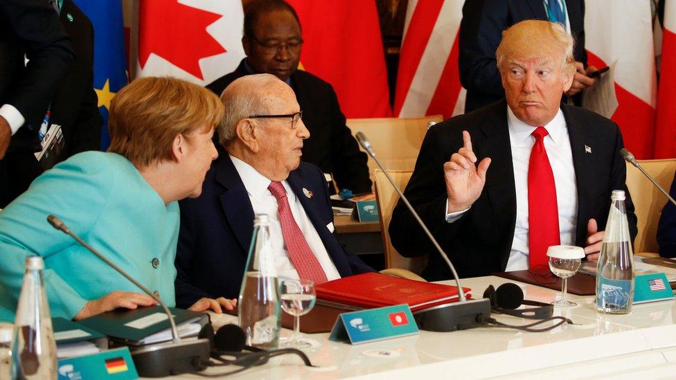 President Trump talks to German Chancellor Angela Merkel (L) and Tunisia's President Beji Caid Essebsi at the G7 summit expanded session in Taormina, Sicily,May 27, 2017