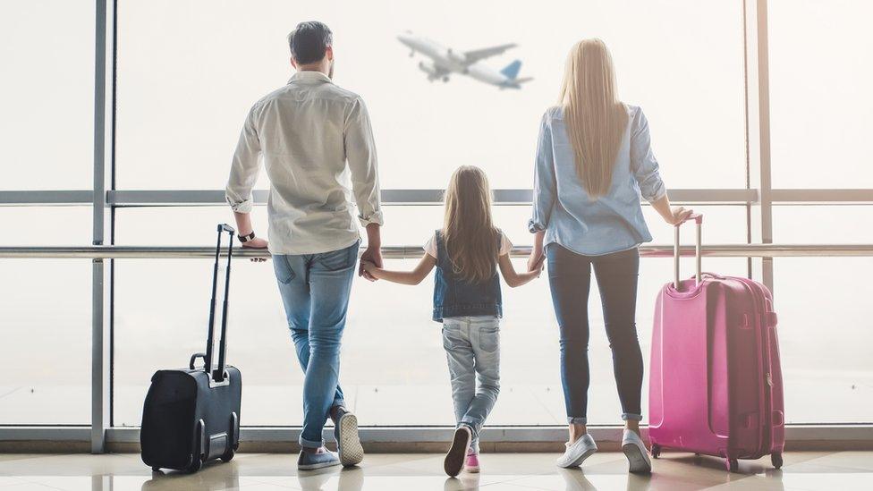 family-in-airport-looking-at-plane.