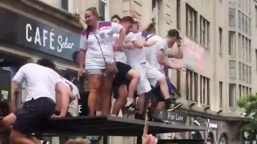 Fans on bus stop in Nottingham after the England v Sweden game