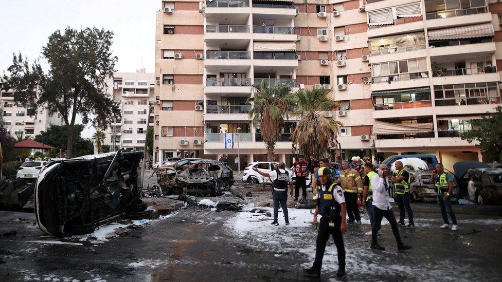 Israeli emergency workers inspect damage caused by rockets fired from Gaza in Ashdod, Israel (31 October 2023)