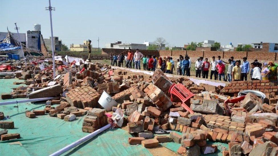 Indian people gather near the debris of a building where at least 24 people were killed when a wall collapsed at a wedding in the Bharatpur district of Rajasthan, India, 11 May 2017.