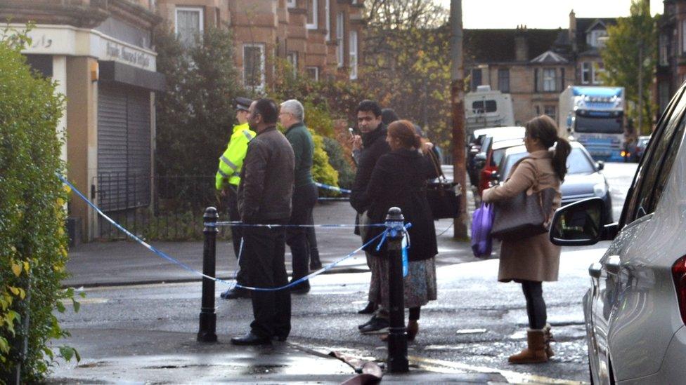 A view of local residents watching the emergency services from the behind the police cordon