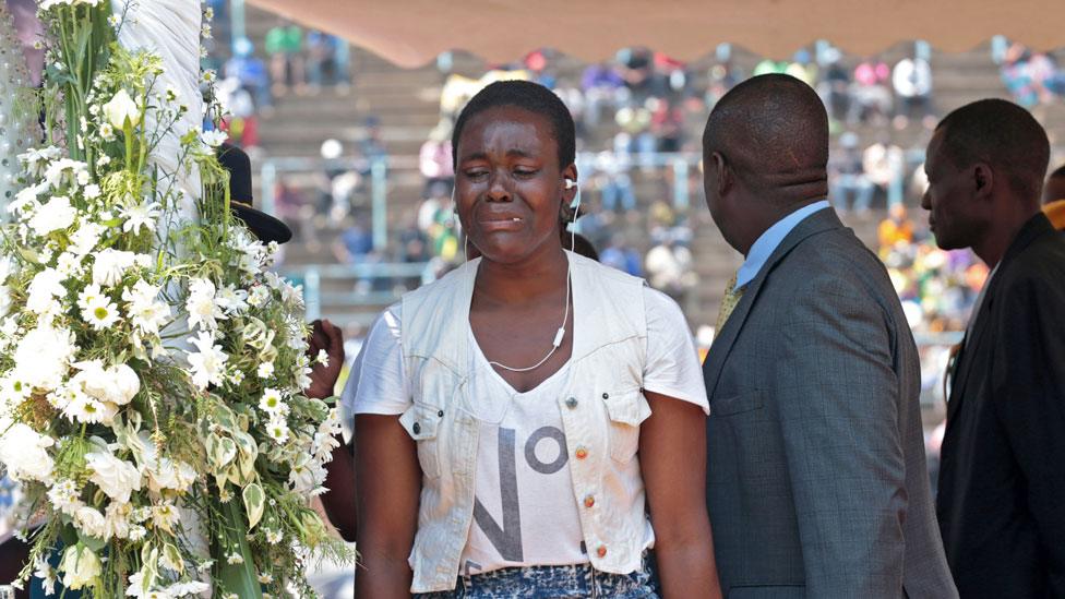 A woman weeps at the public viewing of the body of late former Zimbabwean president Robert Mugabe in the coffin as it is lying in state in Harare, Zimbabwe, 13 September 2019.