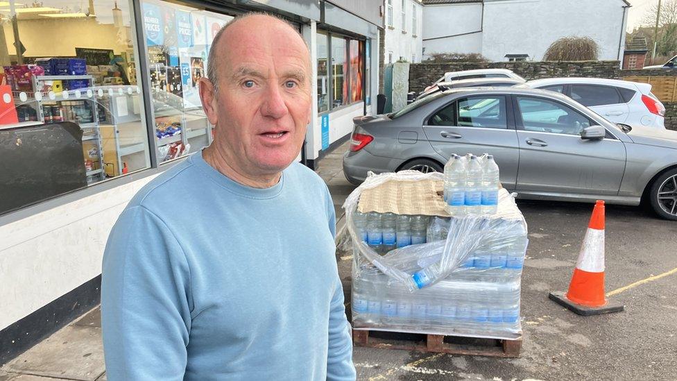 Peter Flowers standing next to bottles of water