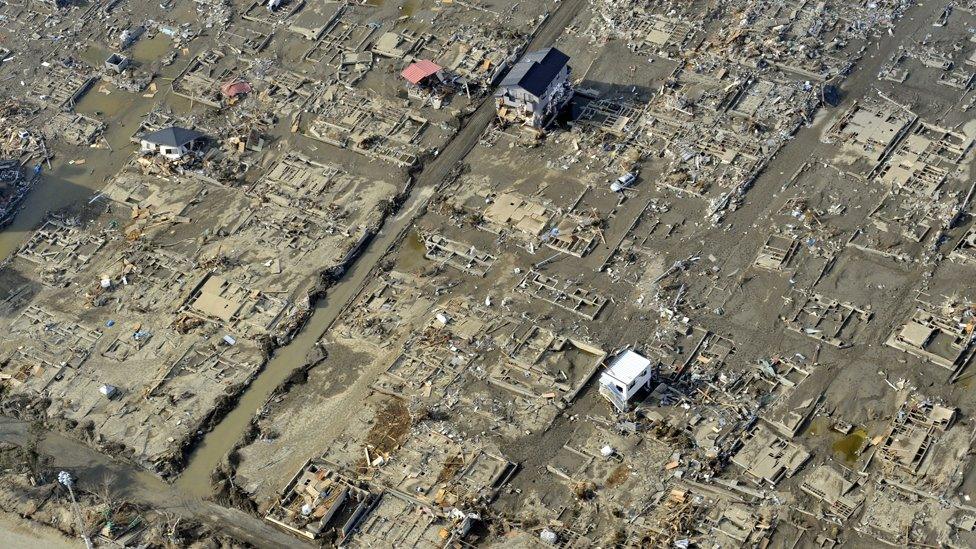 An aerial picture shows just a couple of buildings standing amid blocks of devastation in the town of Ishinomaki (Getty Images)