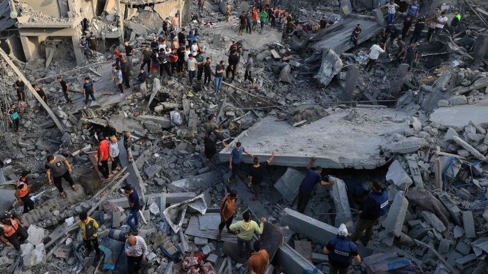 People check the damage caused by a blast at the Al-Maghazi refugee camp