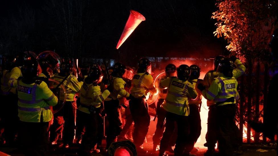 A traffic cone thrown at police