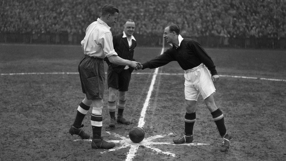 The team captains shake hands