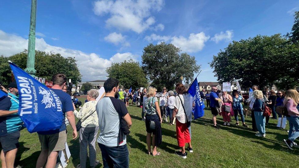 About 50 people striking with blue banners