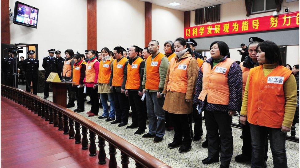 A group of accused members of a child trafficking ring stand before a court in Wuhan, central China's Hubei province on 3 March 2010.