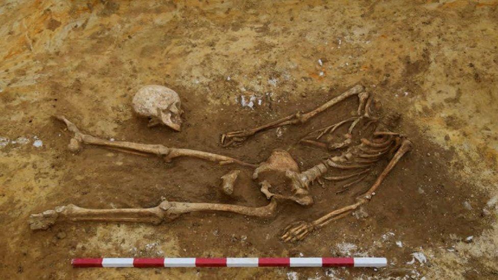 A decapitated Roman skeleton with the skull placed by the knees