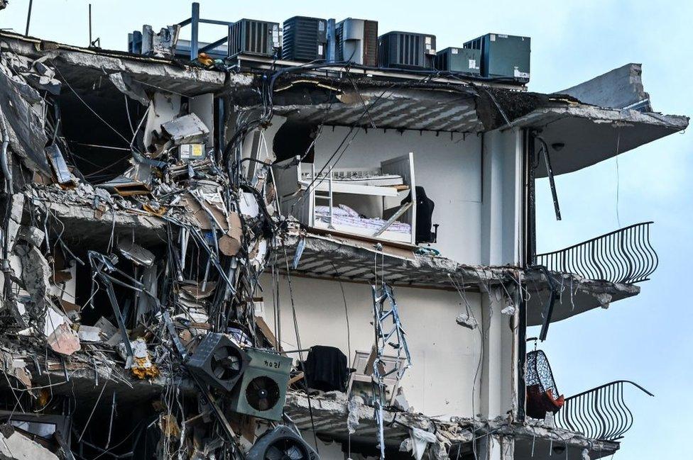 Rubble hangs from a partially collapsed building in Surfside north of Miami Beach, on June 24, 2021.