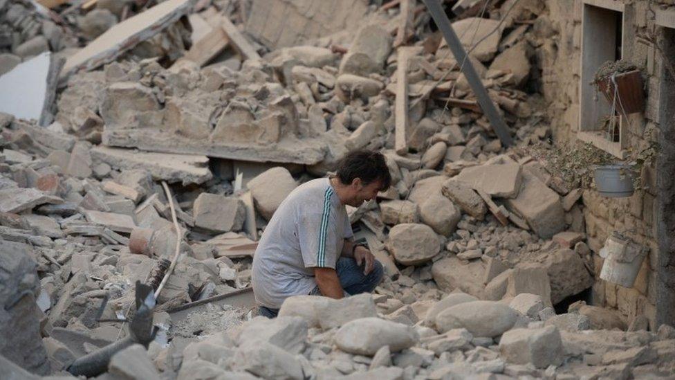 A man reacts to his damaged home after a strong earthquake hit Amatrice on August 24, 2016