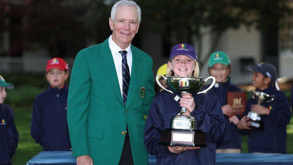 Madison Pyatt winner of the Girl's 7-9 age group holds the winners trophy in the Drive, Chip and Putt Championship.