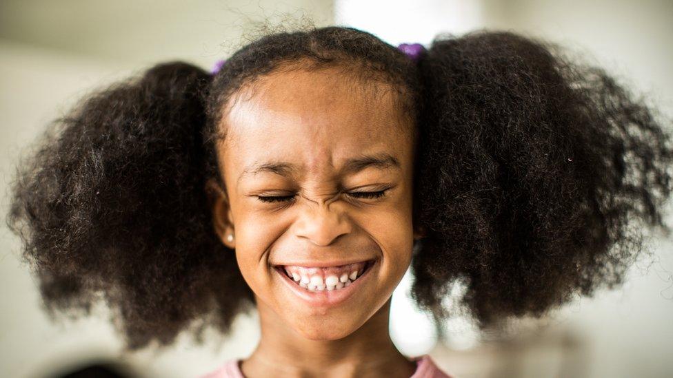 girl with curly hair smiling