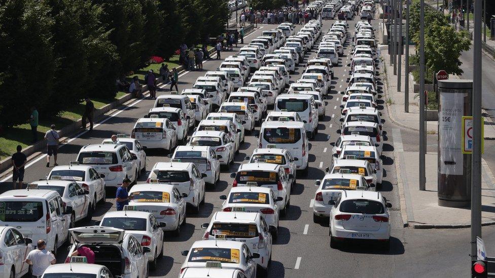 Taxi drivers with their vehicles block the Paseo de la Castellana avenue in downtown during another day of taxi strikes, in Madrid, Spain, 30 July 2018