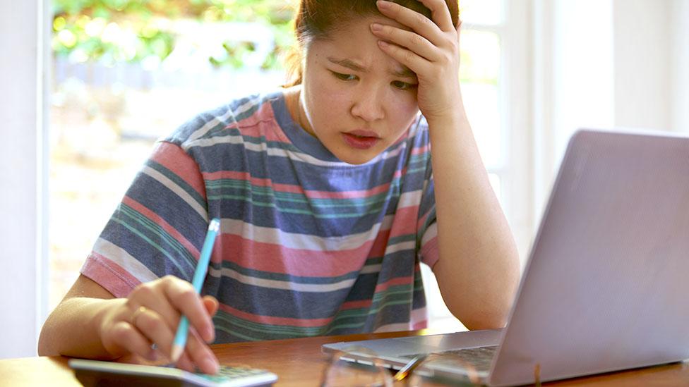 Worried student calculating credit limit overspend