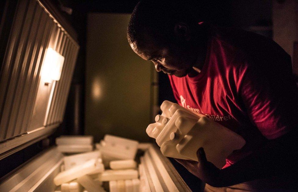 Man taking containers of vaccine out of the fridge