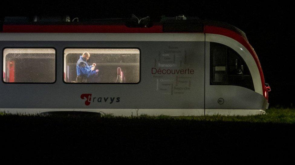 A police office taking photos inside a stopped train