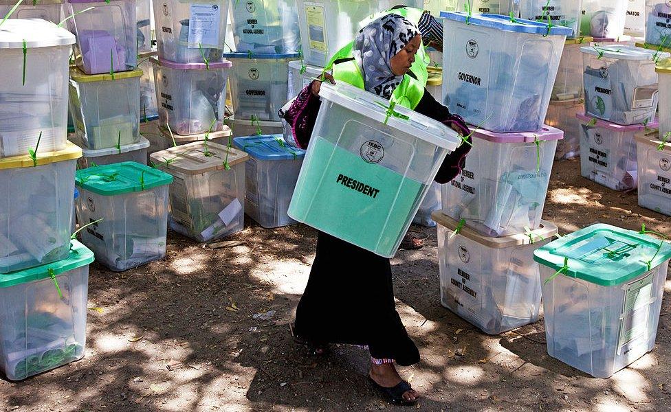 An Independent Electoral and Boundaries Commission (IEBC) official carries closed ballot boxes to be counted in Mombasa