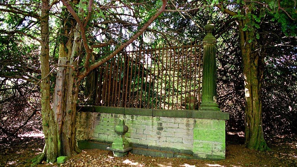 Gated grave surrounded by trees