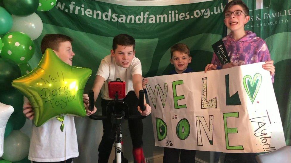 Taylor Hardy surrounded by his brothers on cycling machine