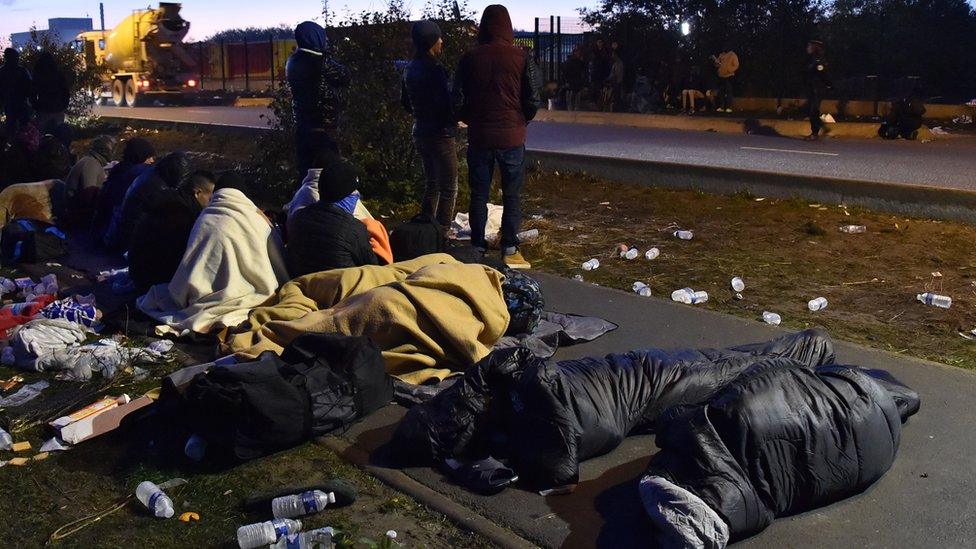 Some refugees sleeping on a pavement outside the Calais camp.