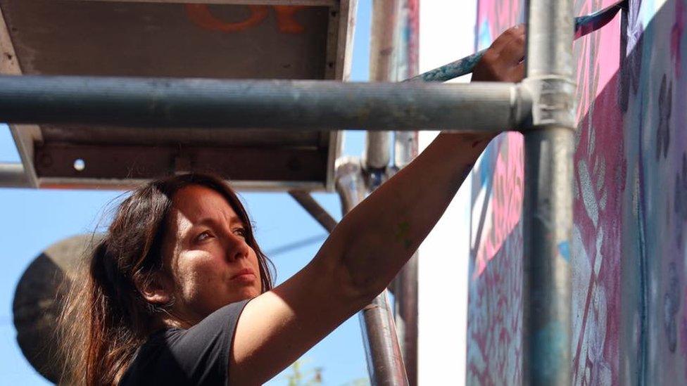 Sian Storey painting a mural