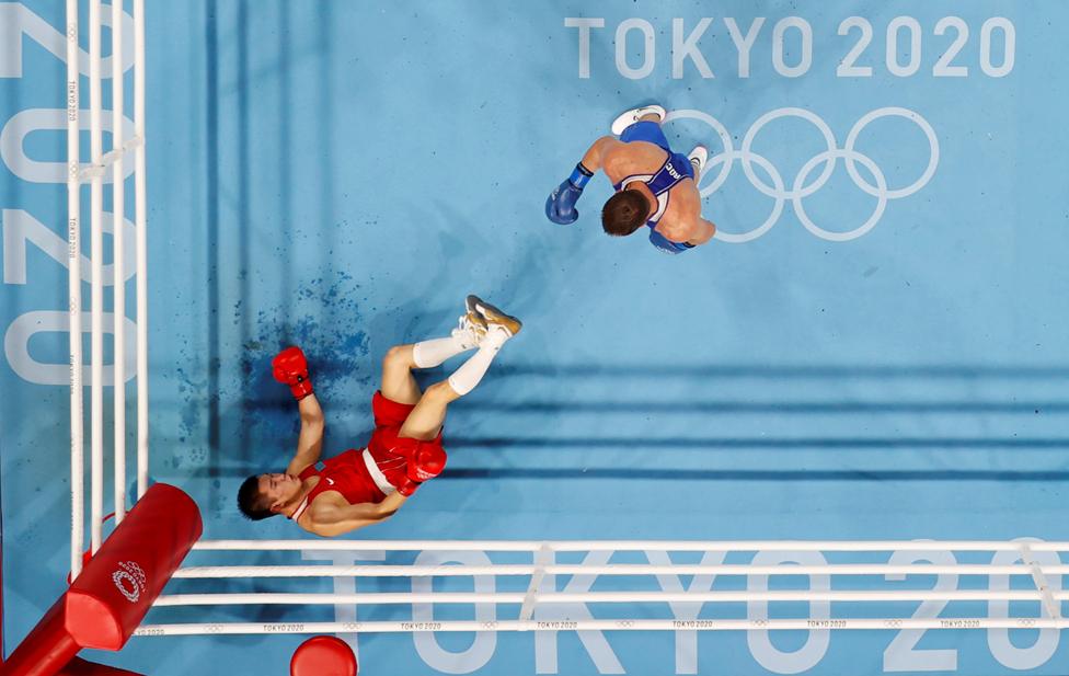 Imam Khataev of the Russian Olympic Committee stands over Bekzad Nurdauletov of Kazakhstan during their Men's Light Heavyweight bout at the Kokugikan Arena, Tokyo, Japan