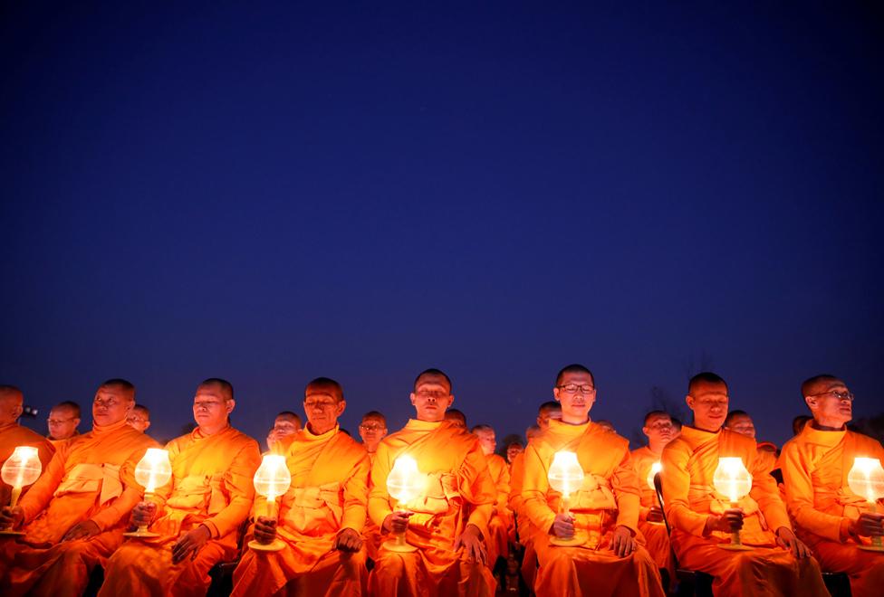 Monks with lit candles attend an event to spread the message of "world peace through inner peace" in Kathmandu, Nepal, 16 March 2019.