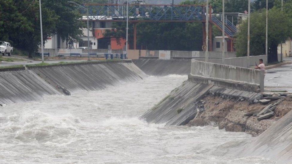 A man takes pictures during Storm Hanna in San Nicolas de los Garza on the outskirts of Monterrey, Mexico July 26, 2020