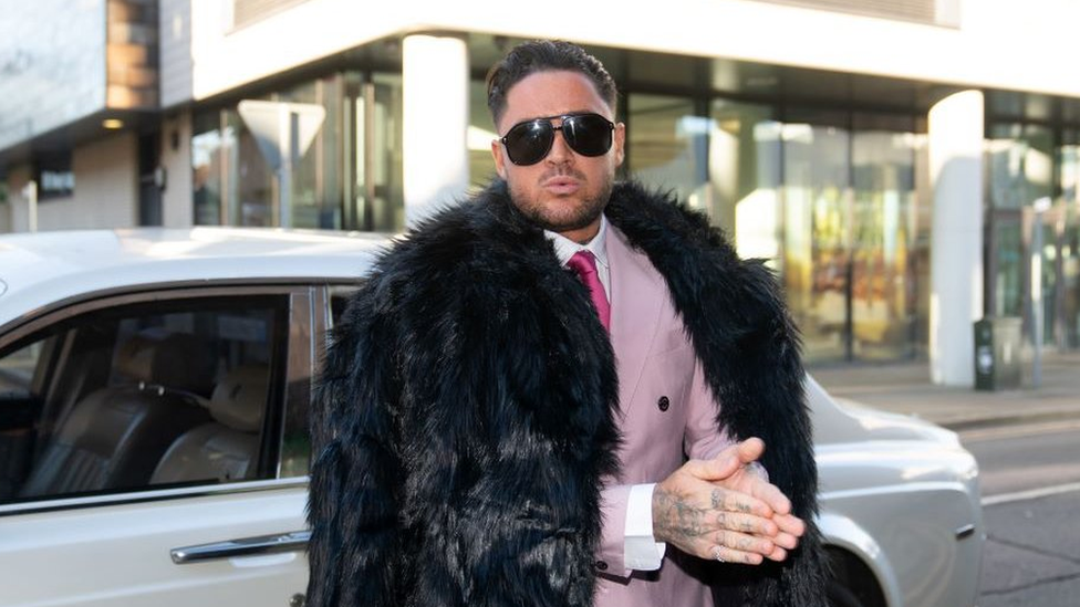 Stephen Bear dressed in a pink suit and tie with black fur coat outside Chelmsford Crown Court