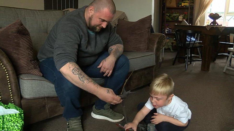 Father and son playing with toys in the living room of their house