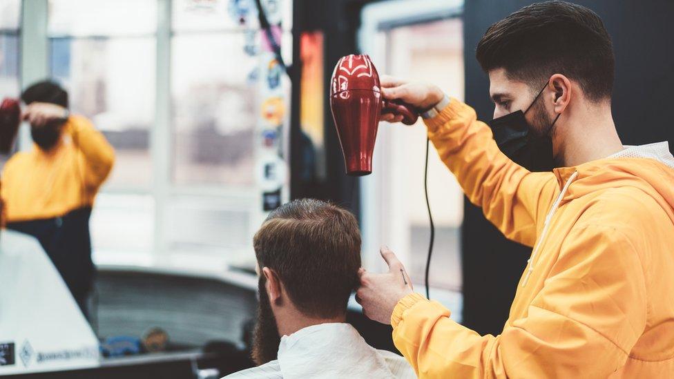 A hairdresser wearing a mask