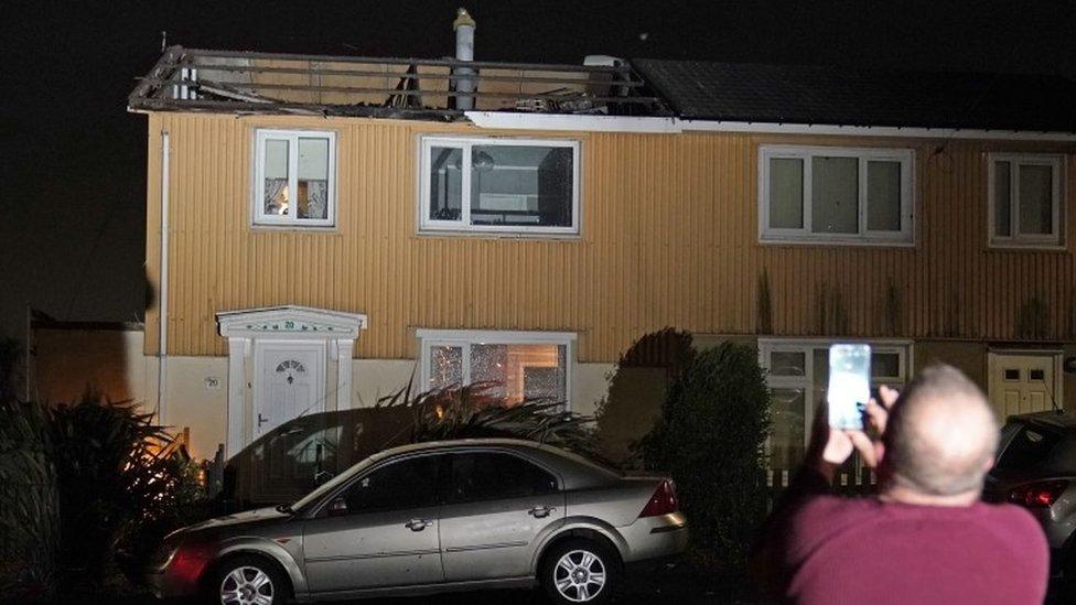 A homeowner, who lost the roof of his house in strong winds, takes a picture of his property in Blackhall, County Durham