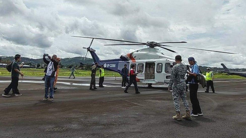 Rescuers prepare to board helicopter to look for survivors of plane crash on Mayon volcano.